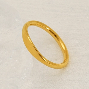 Macro shot of minimalist 18K gold plated stainless steel ring on textured background