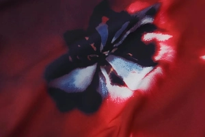 Macro view of abstract flower print on red and black sleeveless long dress fabric