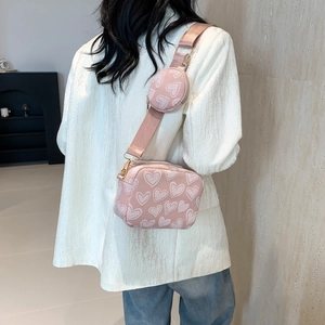 Pink crossbody pillow bag with embossed heart pattern and a matching round coin purse