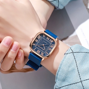 Montre carrée élégante en or rose avec cadran bleu portée par une femme