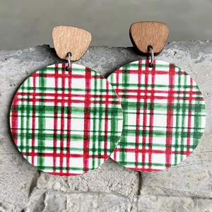 Minimalist wooden earrings with red and green plaid round pendants on a stone surface