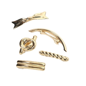 Set of five elegant gold metal hair clips in various minimalist designs on white background