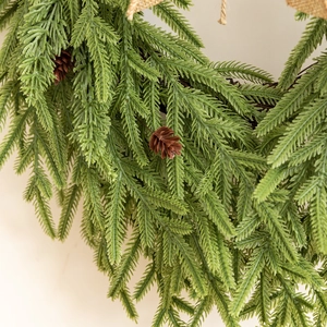Gros plan d'aiguilles de pin vertes réalistes et de pommes de pin sur une couronne de Noël