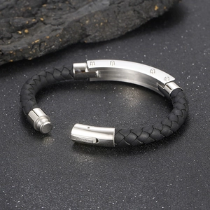 Close-up of titanium steel leather bracelet with polished metal magnetic clasp on rock