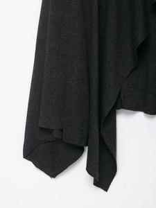 Gros plan sur l'ourlet drapé asymétrique d'une robe midi en maille gris foncé