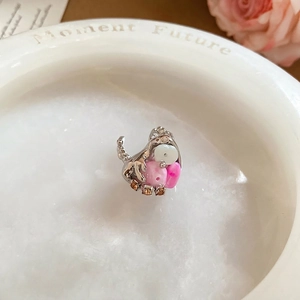 Irregular liquid silver flower ring with pink beads and amber gems on stone texture