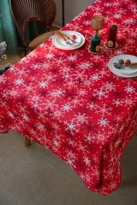 Close-up of red Christmas tablecloth with white snowflake patterns on a dining table