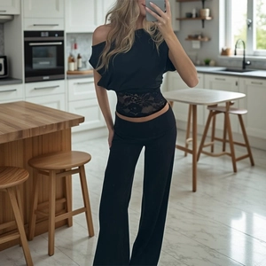 Detail showing sheer lace patchwork waist on black off-shoulder top and high waist pants
