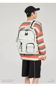 Rear view of model wearing a white high-capacity school backpack with black trim detail