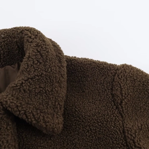 Close-up of deep brown fleece coat neckline showing thick fuzzy texture and collar detail