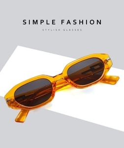 Chic amber orange cat-eye sunglasses with dark grey lenses on simple fashion background