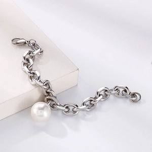 Detailed shot of chunky silver chain bracelet with a large white pearl pendant