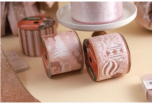Detail of rose gold Christmas ribbon rolls featuring reindeer and snowflake glitter patterns