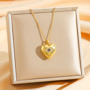 Vintage heart locket necklace with devil eye design on elegant champagne silk background
