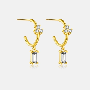 Close-up of gold S925 silver earrings with rectangle zircon pendant on white background