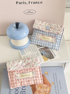 Detailed view of quilted cotton storage pouches in pink and blue floral patterns