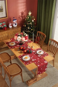 Close-up of red festive table runner and mats with snowflake and bell patterns