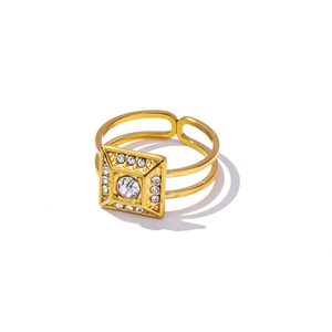 Golden square geometric ring with central crystal and double hollow band on white backdrop