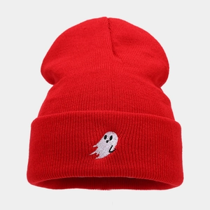 Macro detail of red knitted beanie featuring a white ghost embroidery on the cuff fold