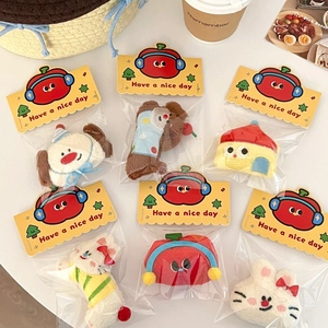 Flat lay of cute plush cartoon hair clips in individual packaging on a fresh background