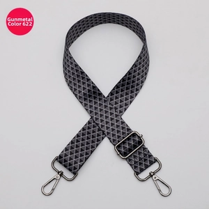 Detail of adjustable woven bag strap with grey geometric pattern and gunmetal hardware