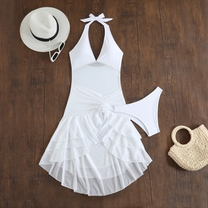 Flat lay of white halter bikini set with layered ruffles and floral mesh skirt