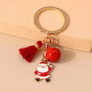 Detailed close-up of Christmas keychain with red bell, tassel and Santa Claus pendant