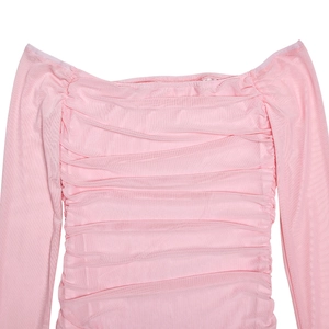 Détail de la robe rose à épaules dénudées avec plis froncés élégants et texture en maille