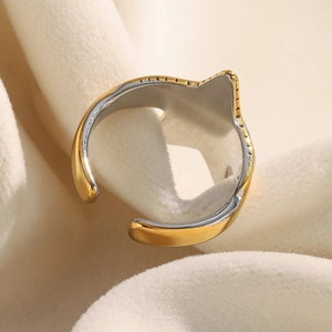 Macro shot of bicolour 18K gold and silver starfish ring on soft beige velvet fabric