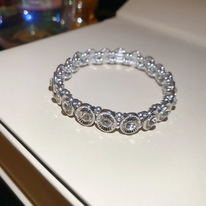 Macro shot of silver elastic bracelet featuring crystal rhinestones and radial textures