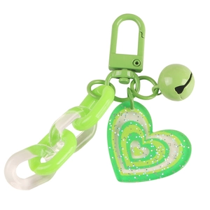 Green glitter heart keychain with colorful acrylic chain and bell on white background