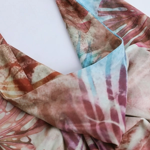 Detail of tropical monstera leaf print on soft fabric with tan and blue gradient tones