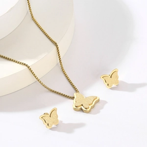 Detail view of golden titanium steel butterfly jewelry set with zircon accents