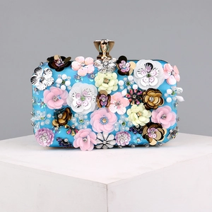 Detailed craftsmanship of handmade 3D floral sequins and beads on a blue evening clutch bag