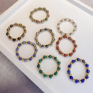 Set of eight elastic natural stone beaded rings with gold stainless steel beads