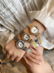 Detailed close-up of three metal watches in silver, gold and rose gold with Roman numerals