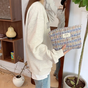 Detail of colorful tweed toiletry bag with textured weave and white textile label