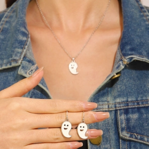 Close-up of ghost necklace and earrings with white enamel and silver chain detail