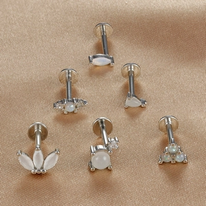 Gros plan de piercings labret en argent S925 avec opales blanches et grappes de zircons