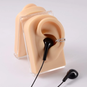 Macro shot of silicone ear model and acrylic stand showing ear clip and headset details