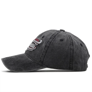 Detail of 3D embroidered Super logo on a vintage washed dark grey cotton baseball cap