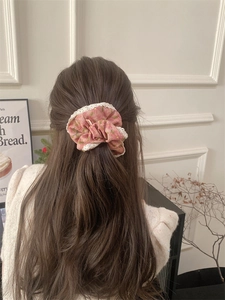 Detail of pink floral corduroy scrunchie with white lace trim on a half-up hairstyle