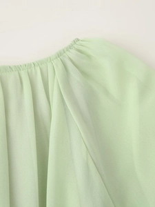 Detailansicht des Rundhalsausschnitts und der weichen Chiffonrüschen am grünen Minikleid