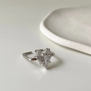 Detail of minimalist 925 silver ring featuring a triangle cut zircon on a white surface