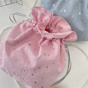 Detail of pink and blue drawstring canvas bags with silver star patterns and ruffled edges