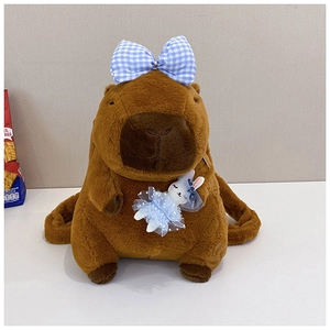 Close-up of plush Capybara backpack featuring a blue checkered bow and rabbit brooch detail