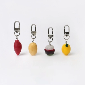 Detailed view of realistic resin vegetable and fruit keychains with metal swivel hooks