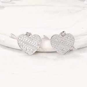 Vue macro de pendentifs cœur et flèche en argent avec incrustation de zircone cubique