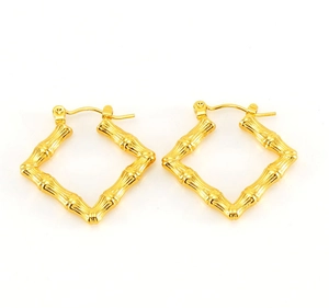 Detail of vintage gold-plated square earrings featuring realistic bamboo texture