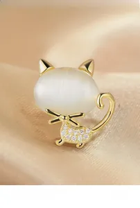 Macro shot of cat-shaped brooch with white opal stone and sparkling zircon pavé
